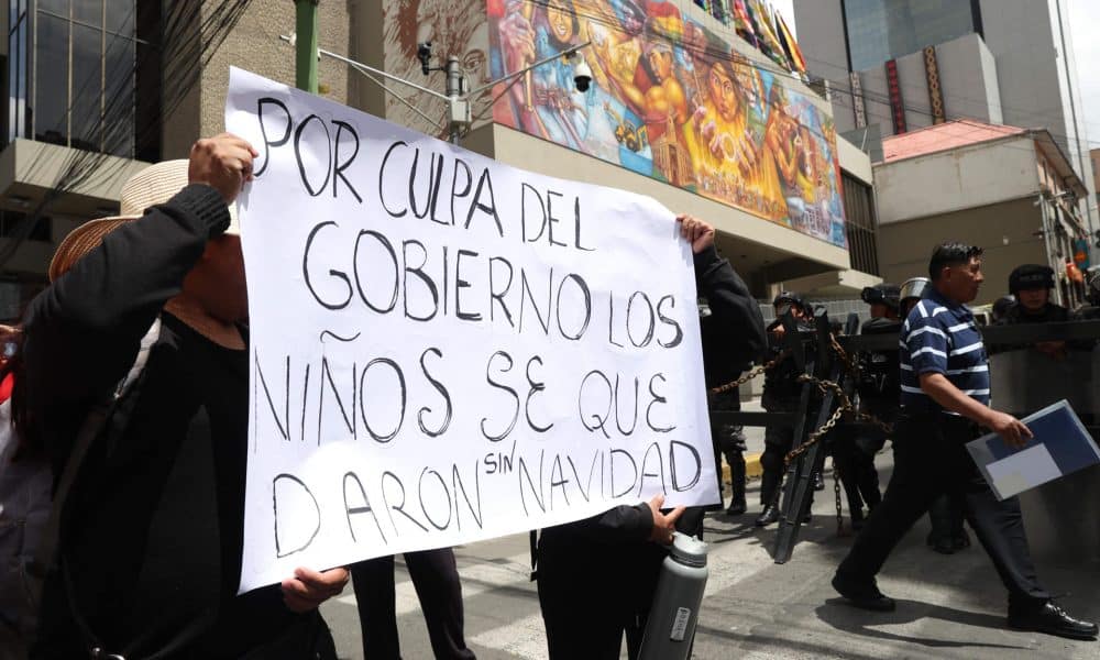 Comerciantes muestran un cartel durante una protesta en contra del levantamiento de la subvención a los combustibles este 19 de diciembre de 2025, en La Paz (Bolivia). EFE/ Luis Gandarillas