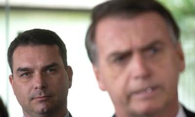 Foto de archivo de julio de 2018 del senador electo Flavio Bolsonaro (i), hijo del expresidente de Brasil, Jair Bolsonaro (d), escucha a su padre durante una rueda de prensa en Brasilia (Brasil). EFE/Joédson Alves