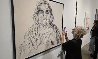 Una mujer toma una fotografía en una exposición este lunes, durante el 'Miami Art Week´ en Miami (Estados Unidos). Miami se transforma en un centro cultural del mundo con el comienzo de la Semana del Arte de Miami, en la que convergen cerca de 20 ferias artísticas y más de 1.200 galerías. EFE/ Alberto Boal