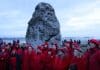 Mujeres vestidas de rojo cantan este domingo ante el monumento megalítico de Stonehenge, cerca de Amesbury (Reino Unido), para celebrar el solsticio de invierno, el día más corto del año en el hemisferio norte. EFE/EPA/NEIL HALL
