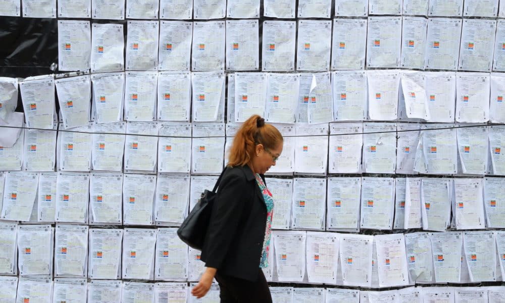 Fotografía del 26 de diciembre de 2025 que muestra a una mujer caminando frente a copias de actas electorales a las afueras del Centro Logístico Electoral (CLE) en Tegucigalpa (Honduras). EFE/ Gustavo Amador