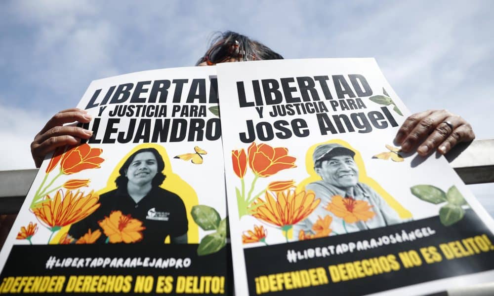 Personas sostienen carteles en apoyo a los activistas y líderes comunitarios Alejandro Henríquez y José Ángel Pérez en El Salvador. EFE/ Rodrigo Sura