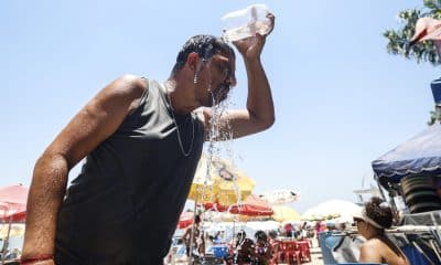 Un hombre se refresca con agua en la playa del lago artificial 'Piscinão de Ramos' este viernes, en Río de Janeiro (Brasil). EFE/ Antonio Lacerda