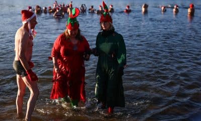 Los miembros del club 'Berlin Seals' asisten al tradicional baño navideño en el lago de Orankesee, en Berlín (Alemania), este jueves 25 de diciembre de 2025. La mayoría de ellos, vestidos con trajes de baño, trajes típicos de la temporada o, al menos, gorros de Papá Noel,se reunieron para su baño anual en las aguas del lago, a temperaturas invernales. EFE/HANNIBAL HANSCHKE