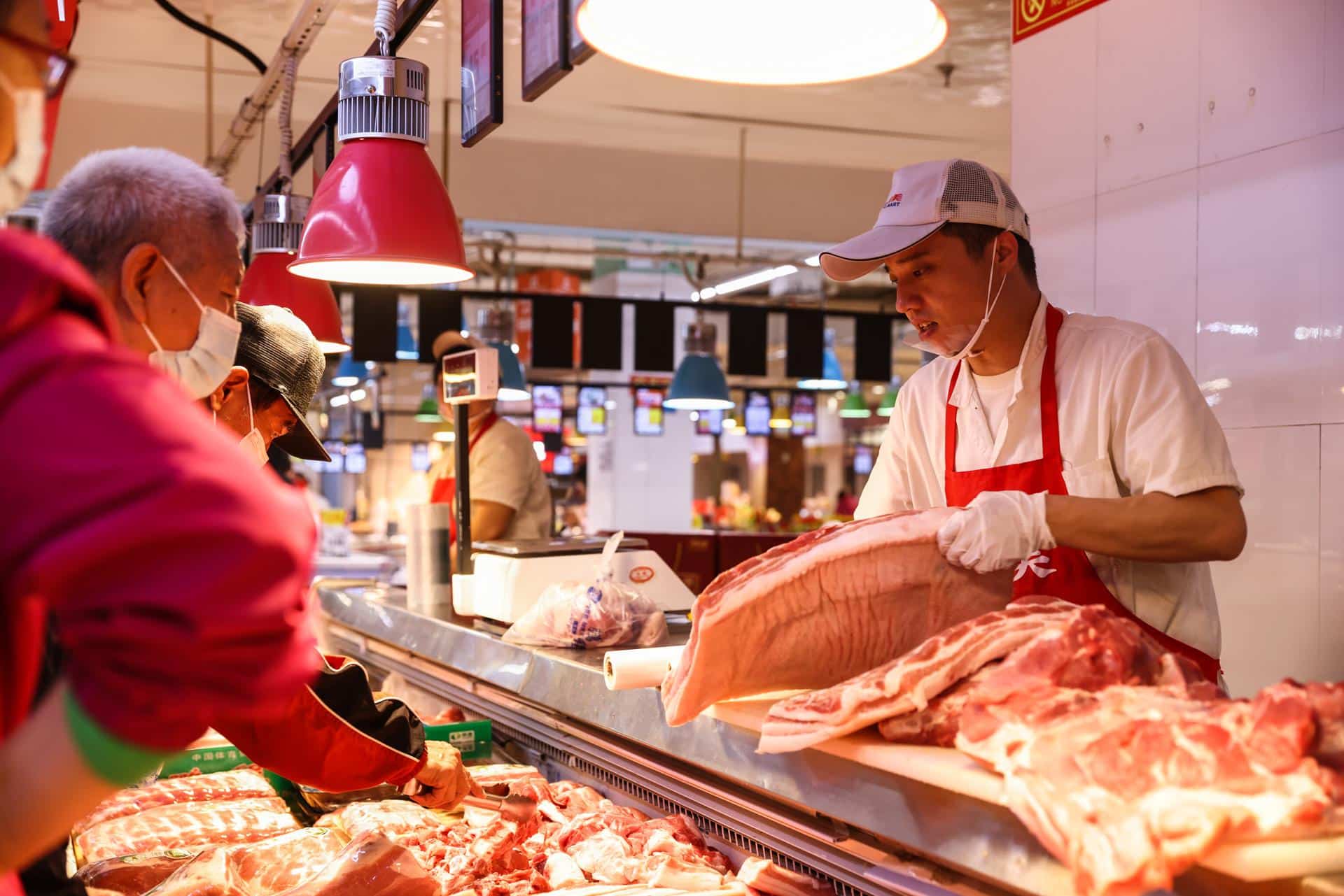Archivo - PEKÍN (China), 10/05/2025.- Un empleado trabaja en un puesto de venta de cerdo en un supermercado de Pekín, China. EFE/EPA/WU HAO