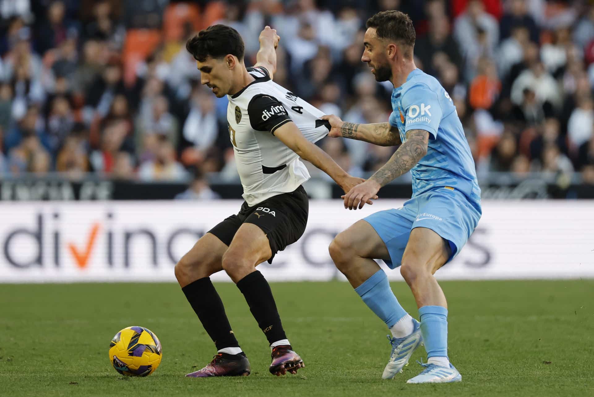 Fotografía de archivo en la que el centrocampista del Valencia Andre Almeida (i) lucha con Sergi Darder, del Mallorca, en un partido de liga en Mestalla. EFE/ Ana Escobar