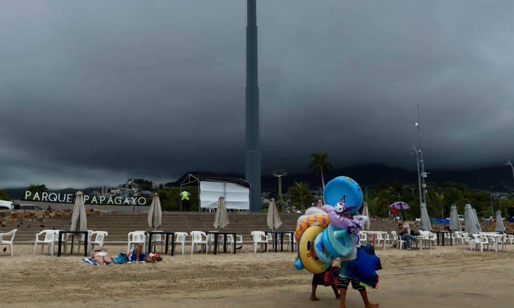 Vendedores caminan en una playa de Acapulco (México). Imagen de archivo. EFE/David Guzmán