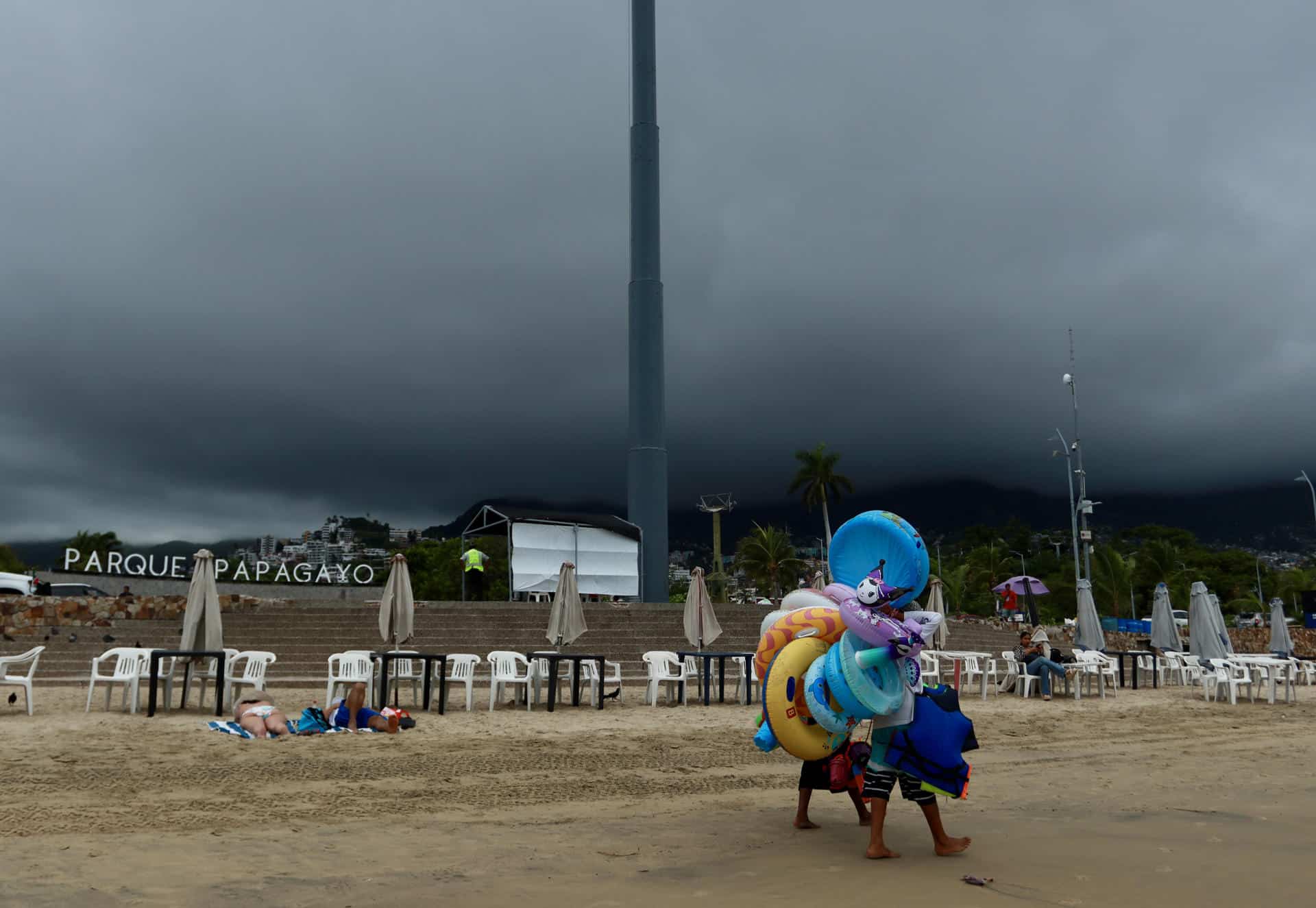 Vendedores caminan en una playa de Acapulco (México). Imagen de archivo. EFE/David Guzmán