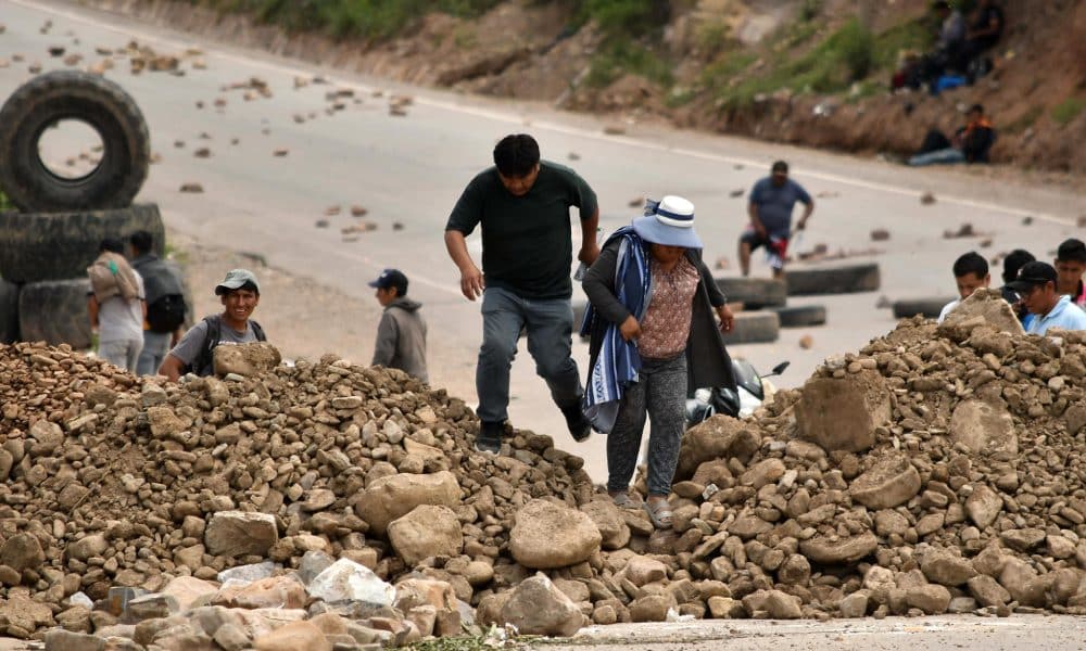Personas caminan en medio de una carretera bloqueada este viernes, en Cochabamba (Bolivia). EFE/ Jorge Abrego