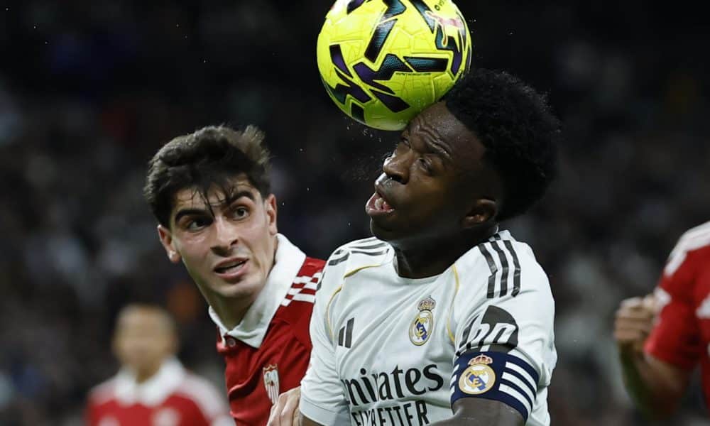 El delantero brasileño del Real Madrid, Vinicius Junior (d), controla el balón ante el defensa del Sevilla, Juanlu Sánchez, en el estadio Santiago Bernabéu, en Madrid. EFE / Juanjo Martín.
