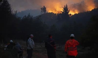 Personas observan un incendio forestal este lunes, en la comuna de Chaimávida, en Concepción a unos 491 km aproximadamente de Santiago (Chile). Los megaincendios originados el sábado pasado han destruido hasta ahora más de 30.000 hectáreas en las regiones de Biobío y Ñuble, a 400 y 500 kilómetros al sur de Santiago, respectivamente, y han obligado a evacuar decenas de miles de personas. EFE/ Adriana Thomasa