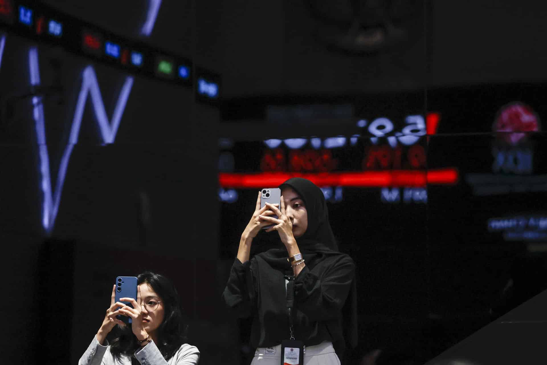 Fotografía de archivo, tomada el 08/04/2025, que muestra a dos mujeres usando teléfonos inteligentes en Indonesia. EFE/EPA/MAST IRHAM