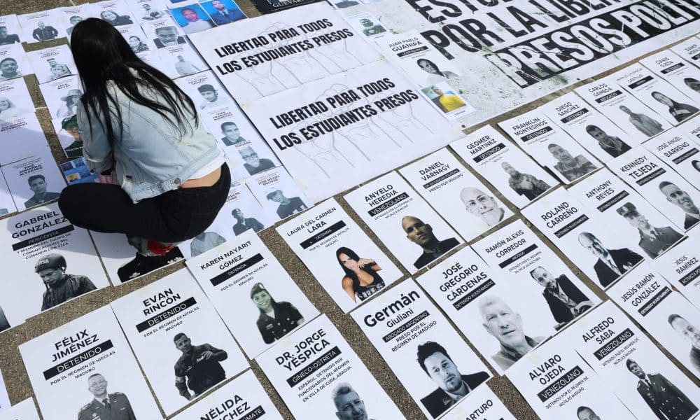 Una persona organiza carteles con imágenes de presos políticos en la Plaza del Rectorado UCV, en Caracas (Venezuela). EFE/ Miguel Gutiérrez