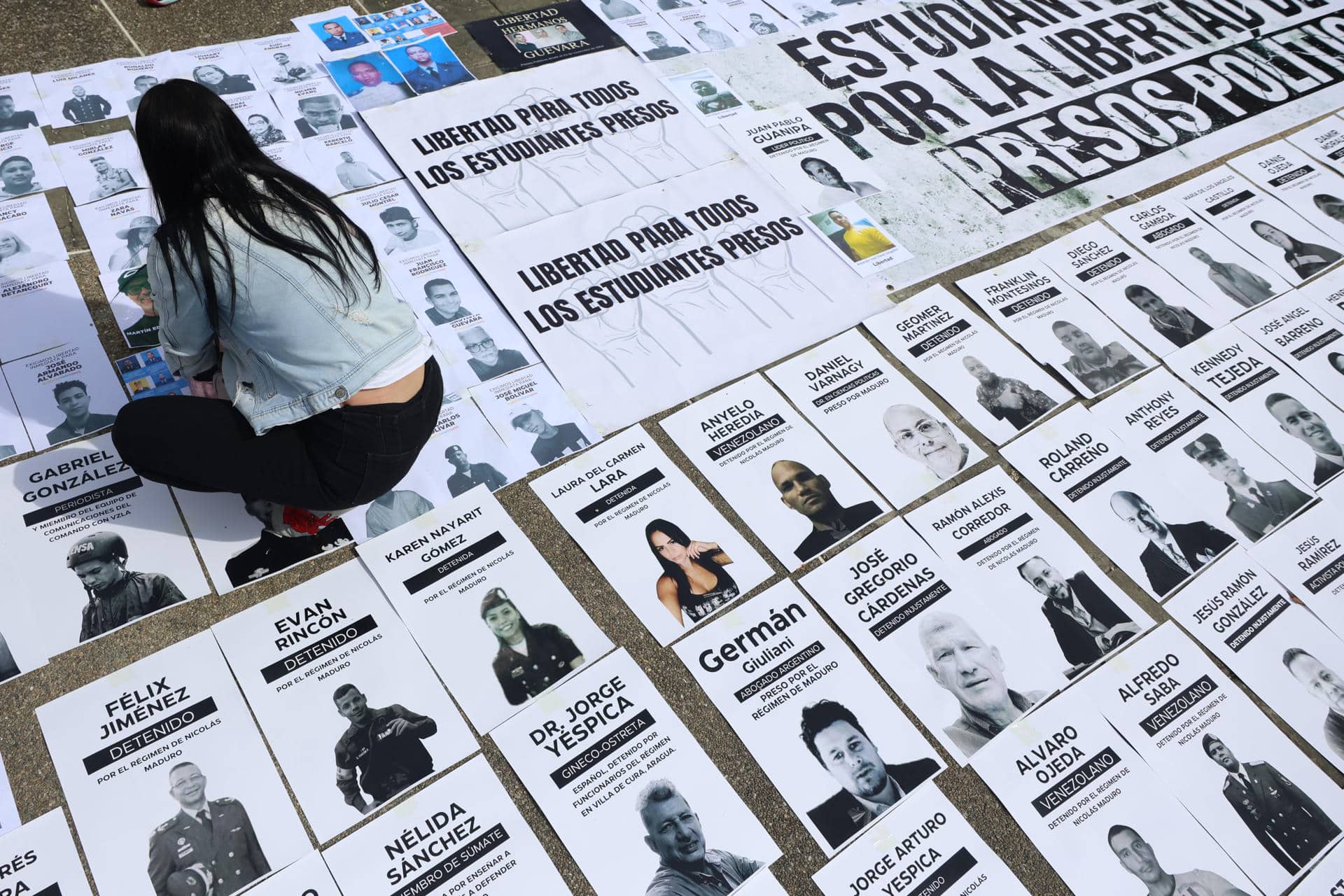 Una persona organiza carteles con imágenes de presos políticos en la Plaza del Rectorado UCV, en Caracas (Venezuela). EFE/ Miguel Gutiérrez