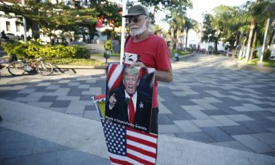 Un hombre sostiene una fotografía del presidente de Estados Unidos, Donald Trump, durante una manifestación en la plaza Simón Bolívar este sábado, en San Salvador (El Salvador). EFE/ Rodrigo Sura