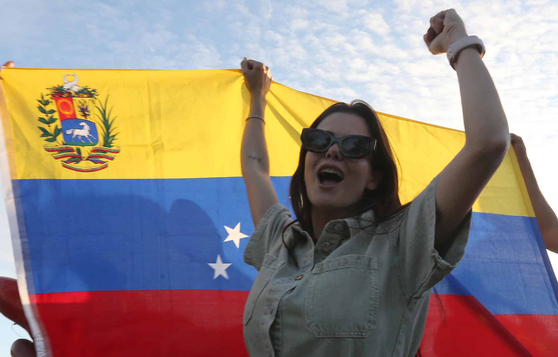 Una persona sostiene una bandera de Venezuela durante una manifestación este 4 de enero de 2026, en Cancún (México). EFE/ Alonso Cupul