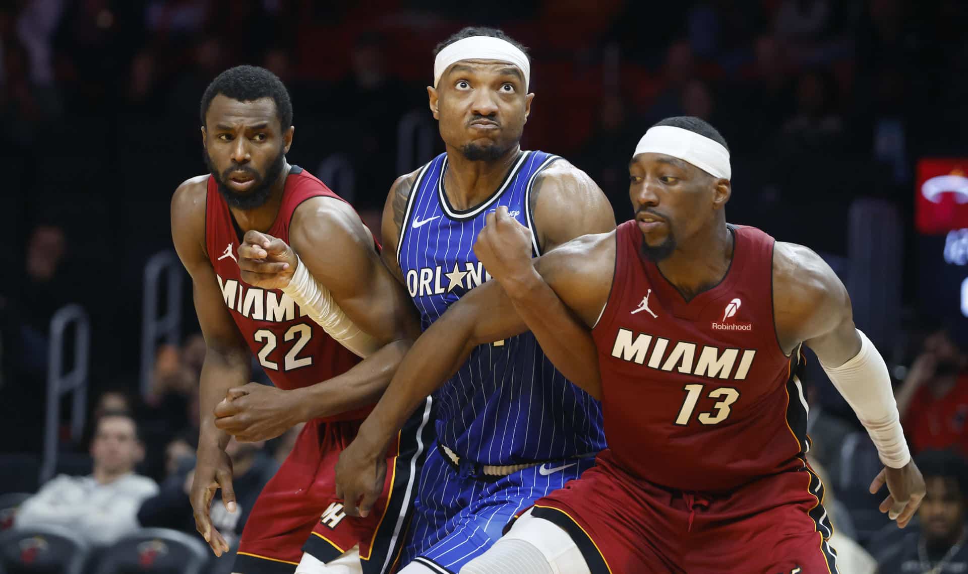 Andrew Wiggins (i) y Bam Adebayo (d) de Miami Heat reaccionan junto a Wendell Carter Jr. de Orlando Magic este miércoles en un partido de la NBA en el Kaseya Center, en Miami, Florida (Estados Unidos). EFE/ Rhona Wise /