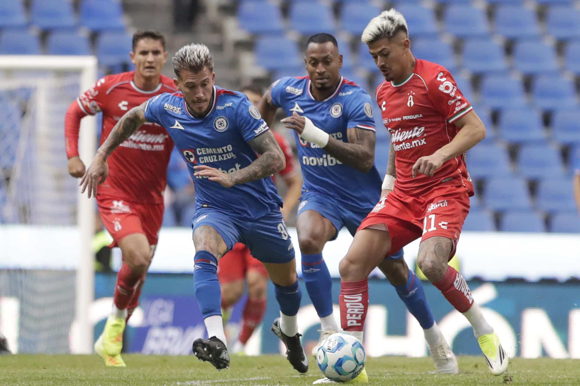 Gonzalo Piovi (i) de Cruz Azul disputa el balón con Diego González de Atlas este miércoles, en un partido de la Liga MX, en el estadio Cuauhtémoc, en Puebla (México). EFE/ Hilda Ríos