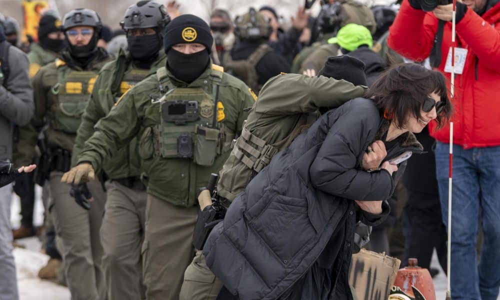 Un integrante de la Policía detiene a una persona durante las protestas frente al edificio Federal Bishop Henry este jueves, en Mineápolis (EE.UU.).  EFE/ Angel Colmenares