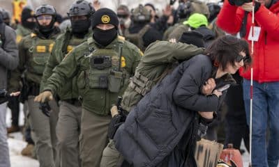 Un integrante de la Policía detiene a una persona durante las protestas frente al edificio Federal Bishop Henry este jueves, en Mineápolis (EE.UU.).  EFE/ Angel Colmenares