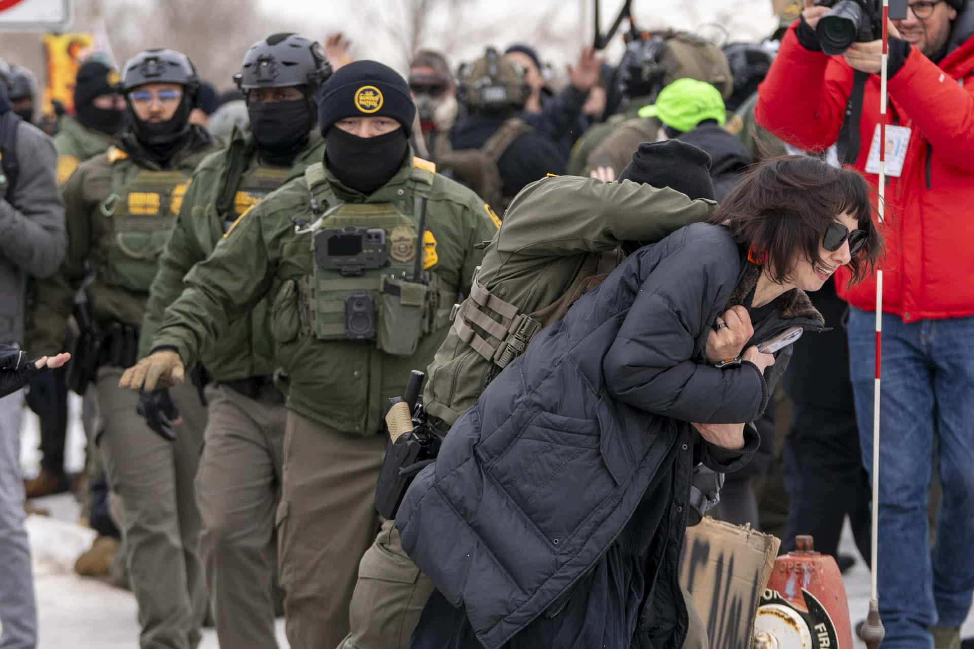Un integrante de la Policía detiene a una persona durante las protestas frente al edificio Federal Bishop Henry este jueves, en Mineápolis (EE.UU.).  EFE/ Angel Colmenares