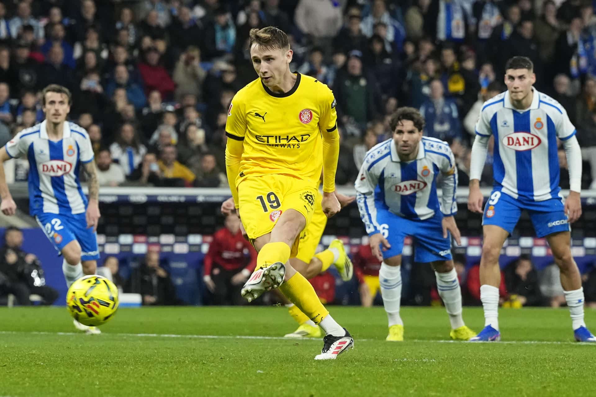 El delantero del Girona Vladyslav Vanat dispara para anotar de penalti el primer gol del equipo durante el partido de LaLiga entre el Espanyol y el Girona, este viernes en el RCDE Stadium. EFE/Enric Fontcuberta