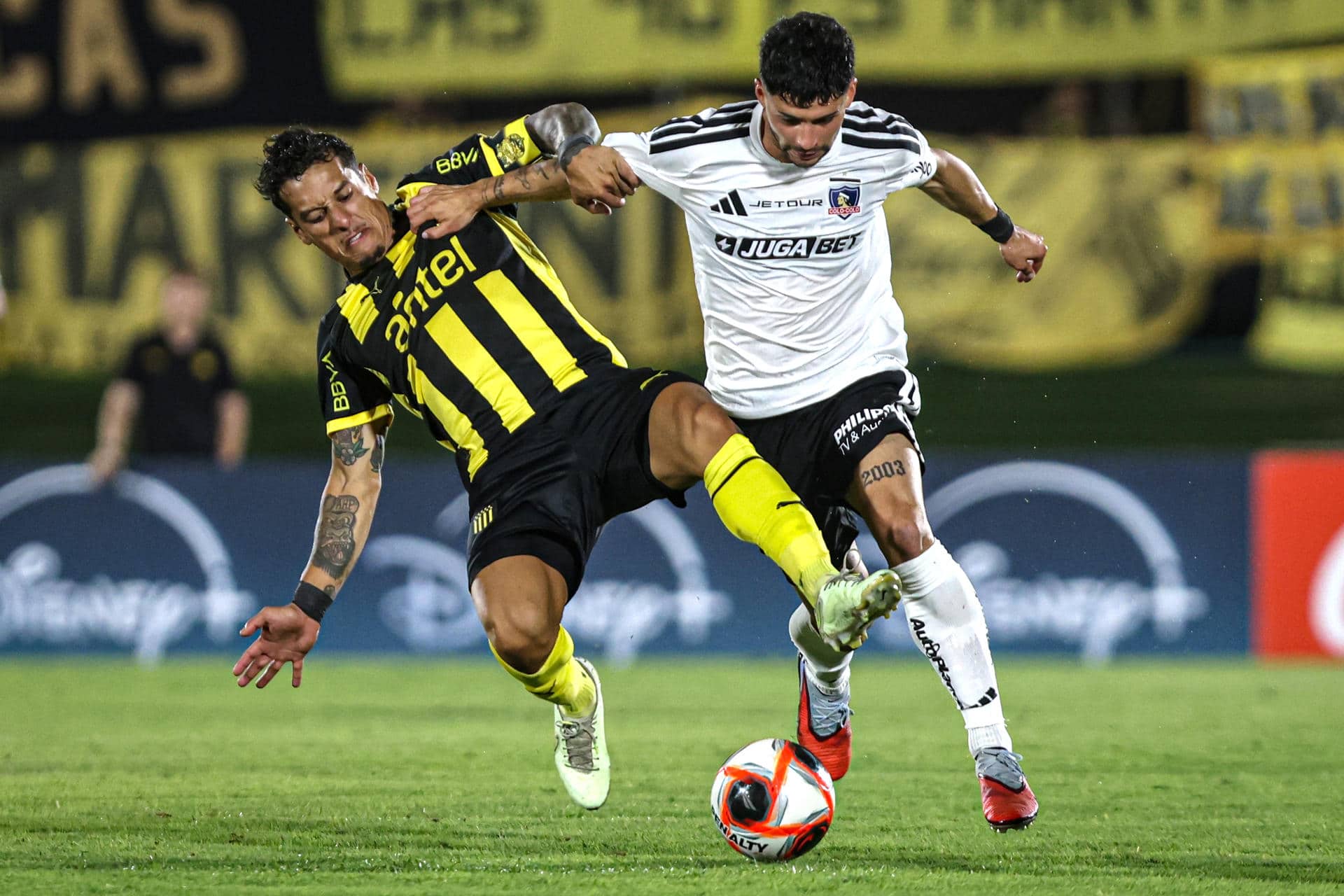 Jesús Trindade (i), de Peñarol, disputa un balón con Cristián Riquelme, de Colo Colo, en un partido de la Serie Río de La Plata entre Peñarol y Colo-Colo en el Estadio Centenario en Montevideo (Uruguay). EFE/Gastón Britos