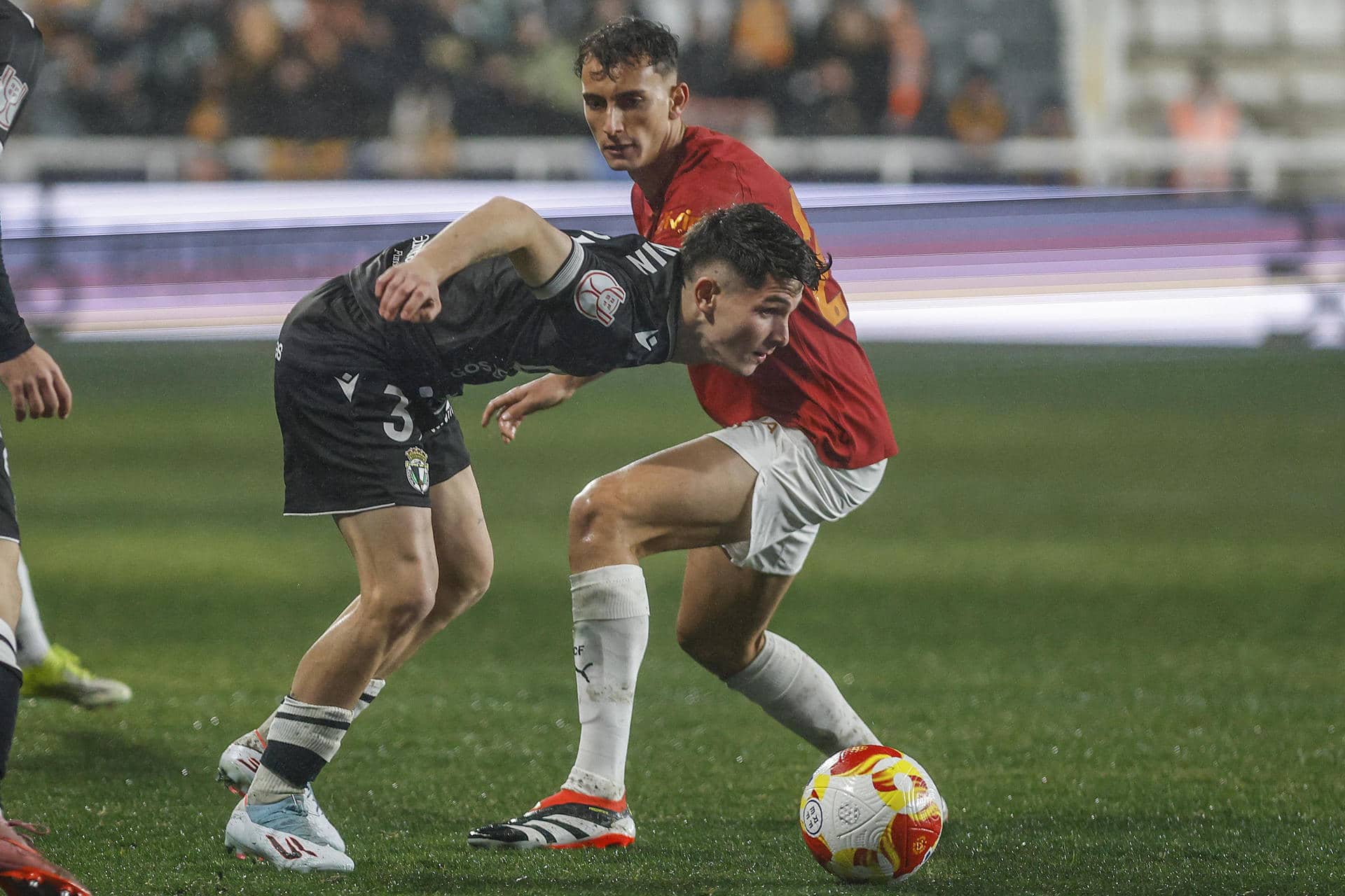 El centrocampista del Burgos Fermín García (i) lucha con Rubén Iranzo, del Valencia, durante el partido de octavos de final de Copa del Rey que Burgos CF y Valencia CF disputan este jueves en el estadio de El Plantío, en Burgos. EFE/Santi Otero