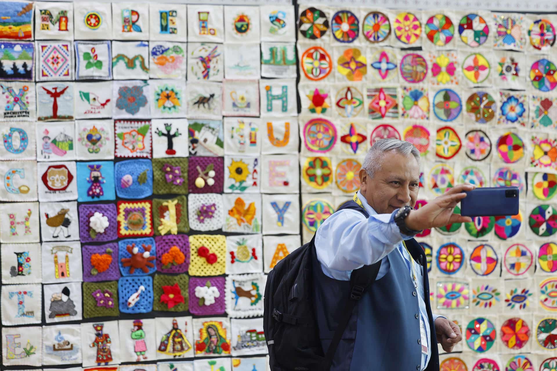 Una persona se toma una fotografía en la exposición de bordados y tejidos más grande del mundo este lunes, en el Complejo Cultural Los Pinos de la Ciudad de México (México). EFE/ Sáshenka Gutiérrez