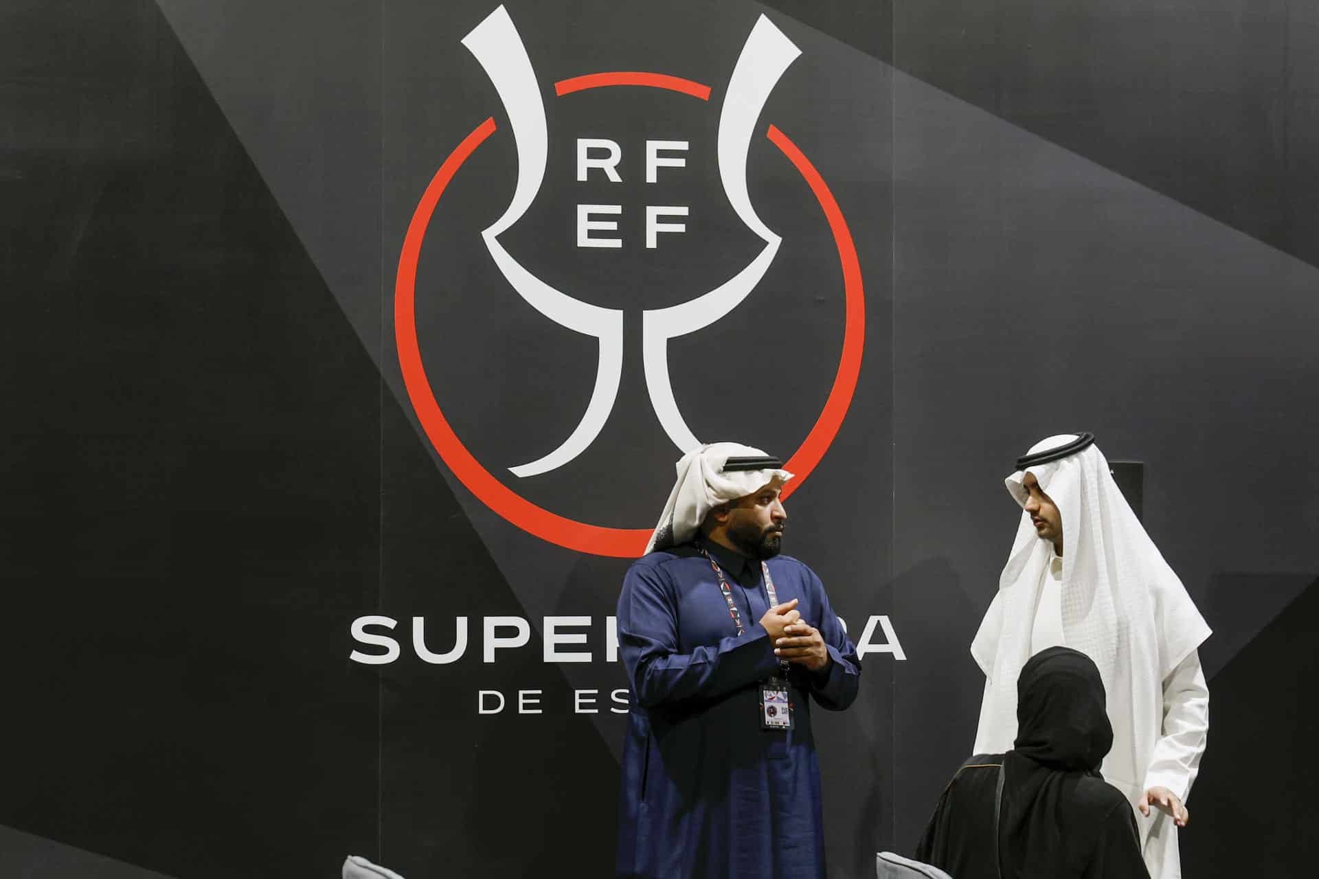 Dos asistentes conversan antes del inicio de la rueda de prensa del Atlético de Madrid y Real Madrid de cara a su enfrentamiento de la Supercopa de España, este miércoles, en la ciudad deportiva King Abdullah en Yeda (Arabia Saudí). EFE/ Kai Forsterling