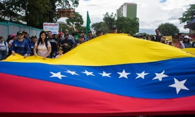 Personas sostienen una bandera durante una manifestación este sábado, en Caracas (Venezuela). EFE/ Boris Vergara