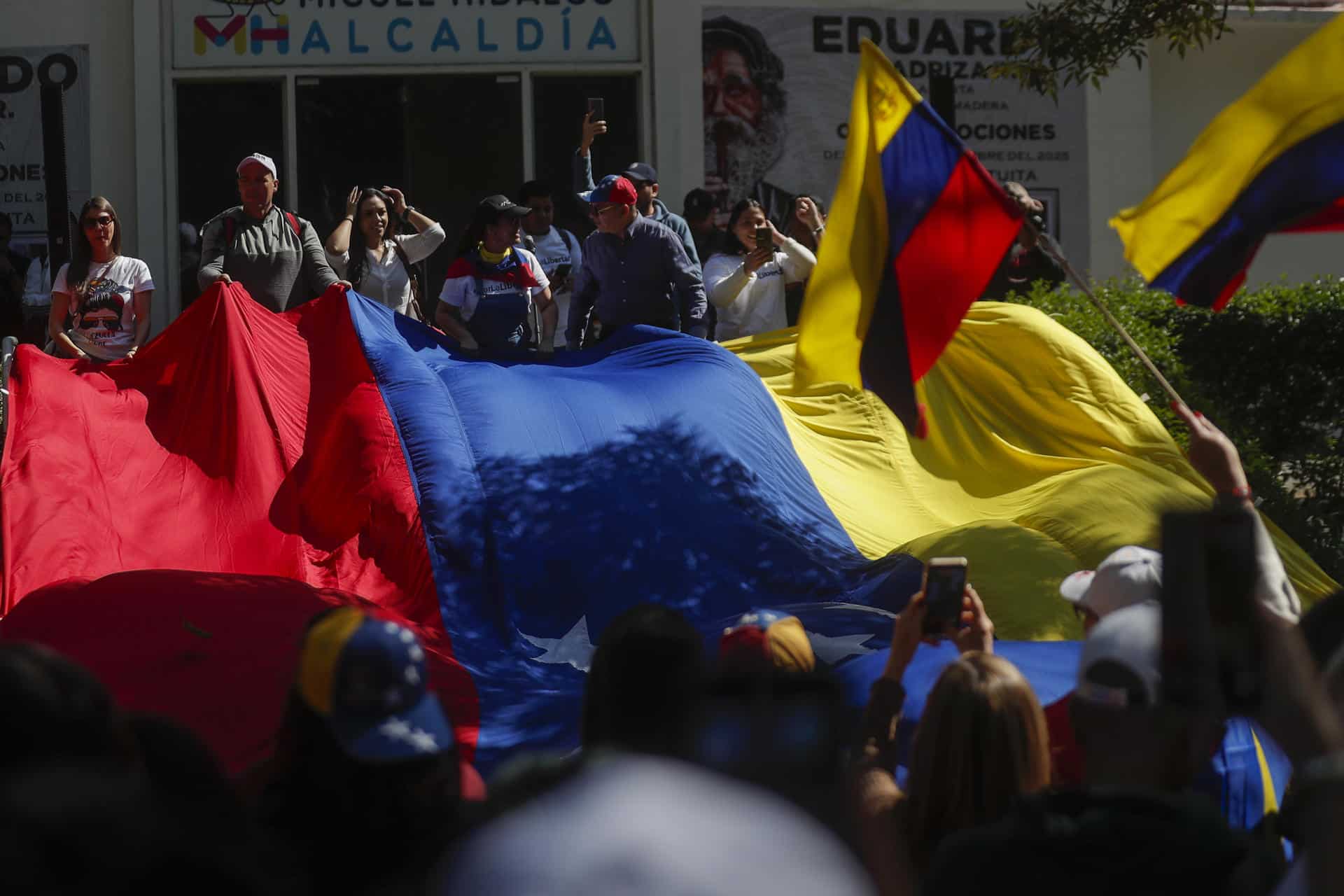 Venezolanos radicados en México ondean una bandera de su país durante una manifestación este domingo, en Ciudad de México (México). EFE/Isaac Esquivel