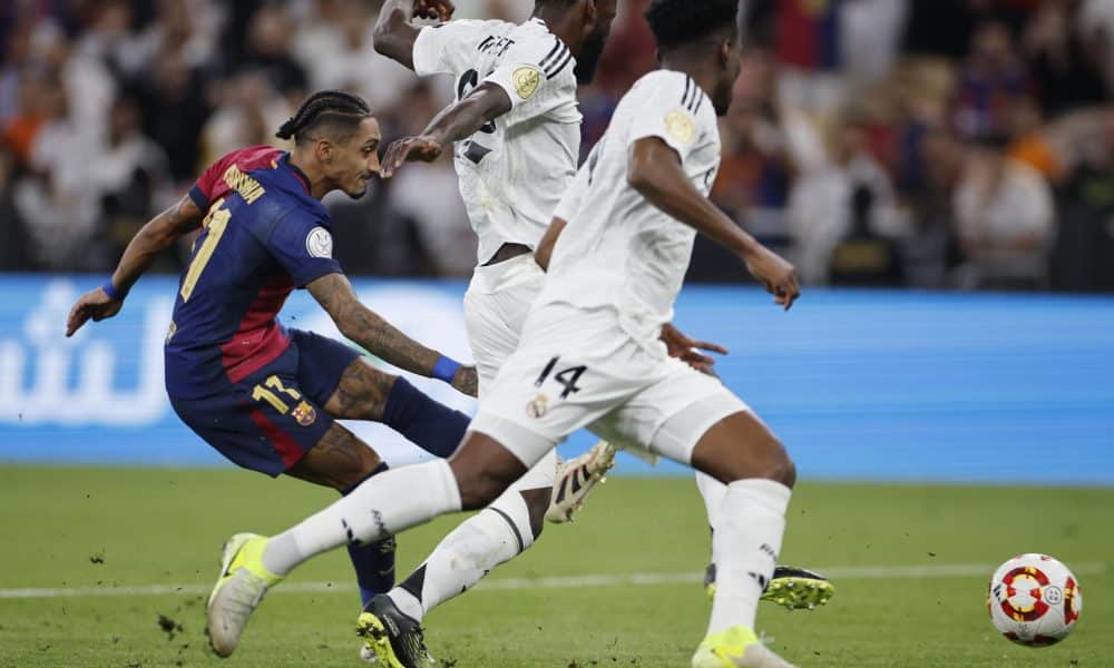 El delantero brasileño del Barcelona Raphinha consigue el quinto gol de su equipo frente a los madridistas Antonio Rudiger (C) y Aurelien Tchouameni (D), durante la final de la Supercopa de España disputada el 12 de enero del pasado año en Yeda, Arabia Saudí. EFE/ Alberto Estévez