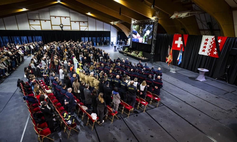 La gente observa un minuto de silencio en memoria de las víctimas mientras ven en una pantalla en el 'Le Regent Congress hall' la ceremonia conmemorativa oficial durante el día nacional de luto tras el incendio mortal en el bar 'Le Constellation' en Crans-Montana, en el Centro de Exposiciones y Convenciones (CERM) de Martigny, Suiza, 09 de enero de 2026. 40 personas, en su mayoría adolescentes, perdieron la vida y 116 resultaron gravemente heridas en el incendio en el bar 'Le Constellation' durante la celebración de Año Nuevo en el balneario alpino suizo de Crans-Montana. (Suiza) EFE/EPA/JEAN-CHRISTOPHE BOTT
