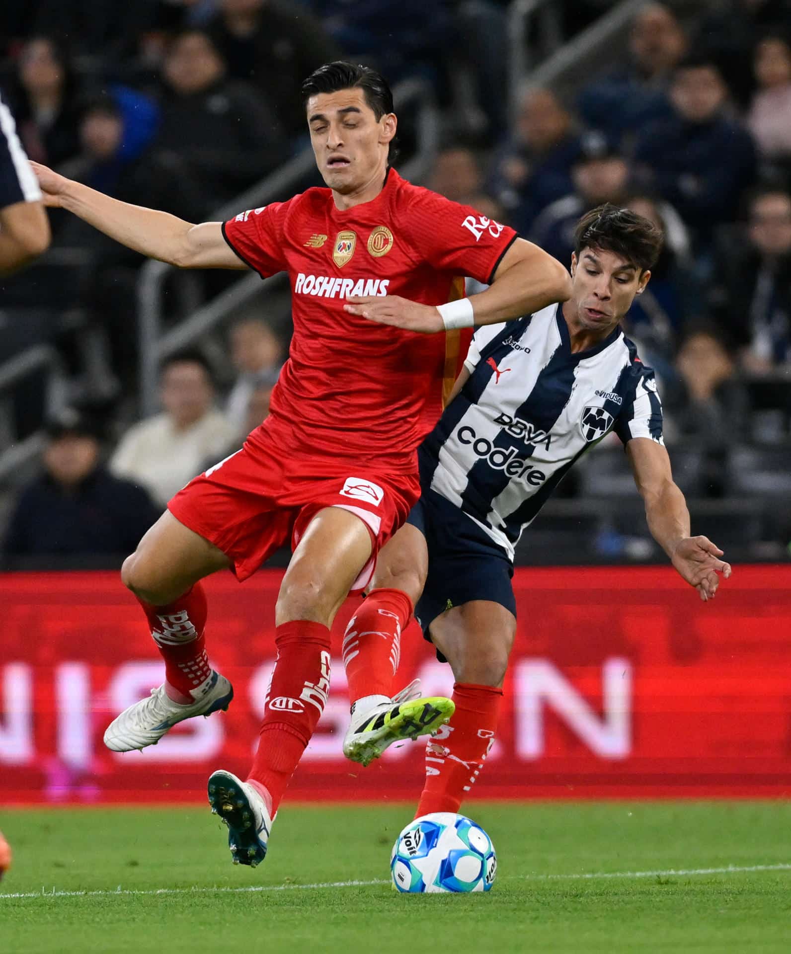 Oliver Torres (d), de Monterrey, disputa el balón con Fernando Arce, de Toluca, en un partido por la jornada 1 del Torneo Clausura 2026 en el estadio BBVA en Guadalupe (México). EFE/Miguel Sierra