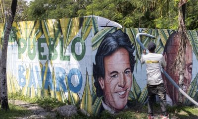 Una persona realiza labores de limpieza frente a un mural con los rostros de los artistas Julio Iglesias y Johnny Ventura en Punta Cana (República Dominicana). EFE/ Orlando Barría