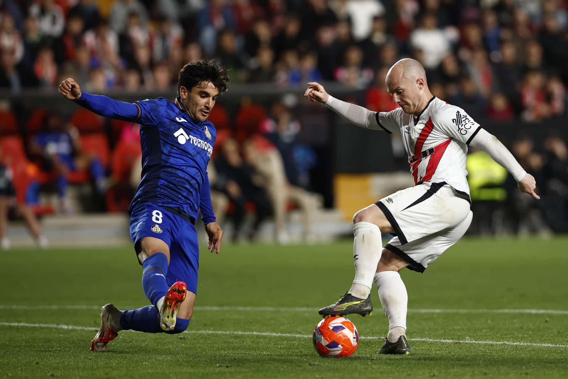 El centrocampista del Rayo Isi Palazón disputa un balón ante el centrocampista uruguayo del Getafe Mauro Arambarri (i), durante un partido entre Rayo Vallecano y Getafe CF. EFE/Daniel González