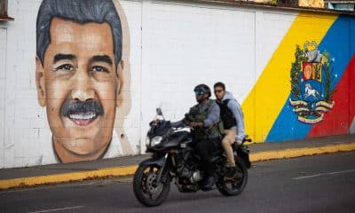 Personas transitan frente a un mural del presidente de Venezuela, Nicolás Maduro, este domingo en Caracas (Venezuela). EFE/ Ronald Peña R