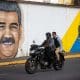 Personas transitan frente a un mural del presidente de Venezuela, Nicolás Maduro, este domingo en Caracas (Venezuela). EFE/ Ronald Peña R