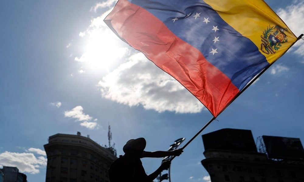 Un ciudadano venezolano ondea una bandera de su país durante una manifestación en apoyo a la intervención de Estados Unidos en Venezuela. EFE/ Juan Ignacio Roncoroni