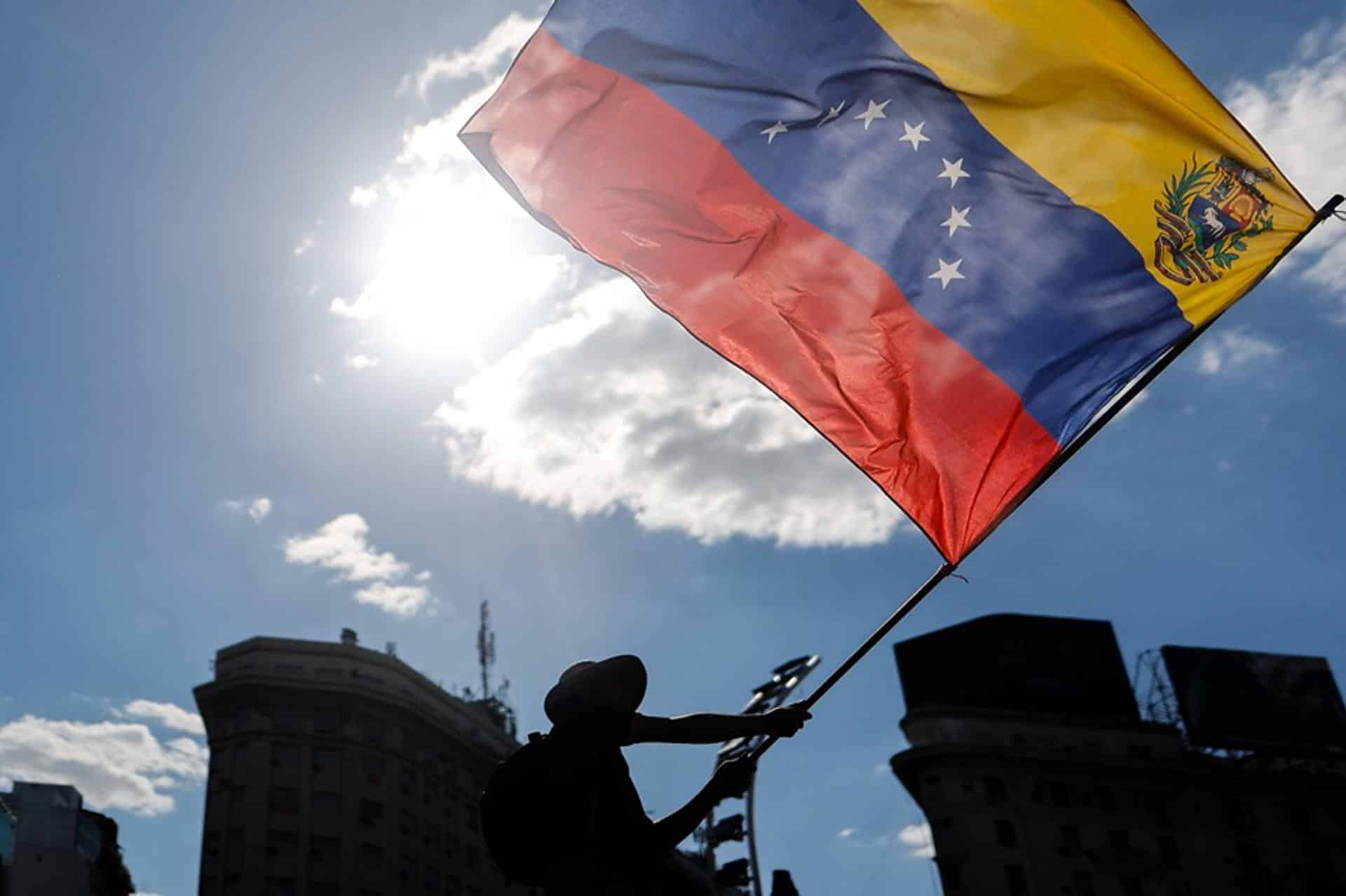 Un ciudadano venezolano ondea una bandera de su país durante una manifestación en apoyo a la intervención de Estados Unidos en Venezuela. EFE/ Juan Ignacio Roncoroni