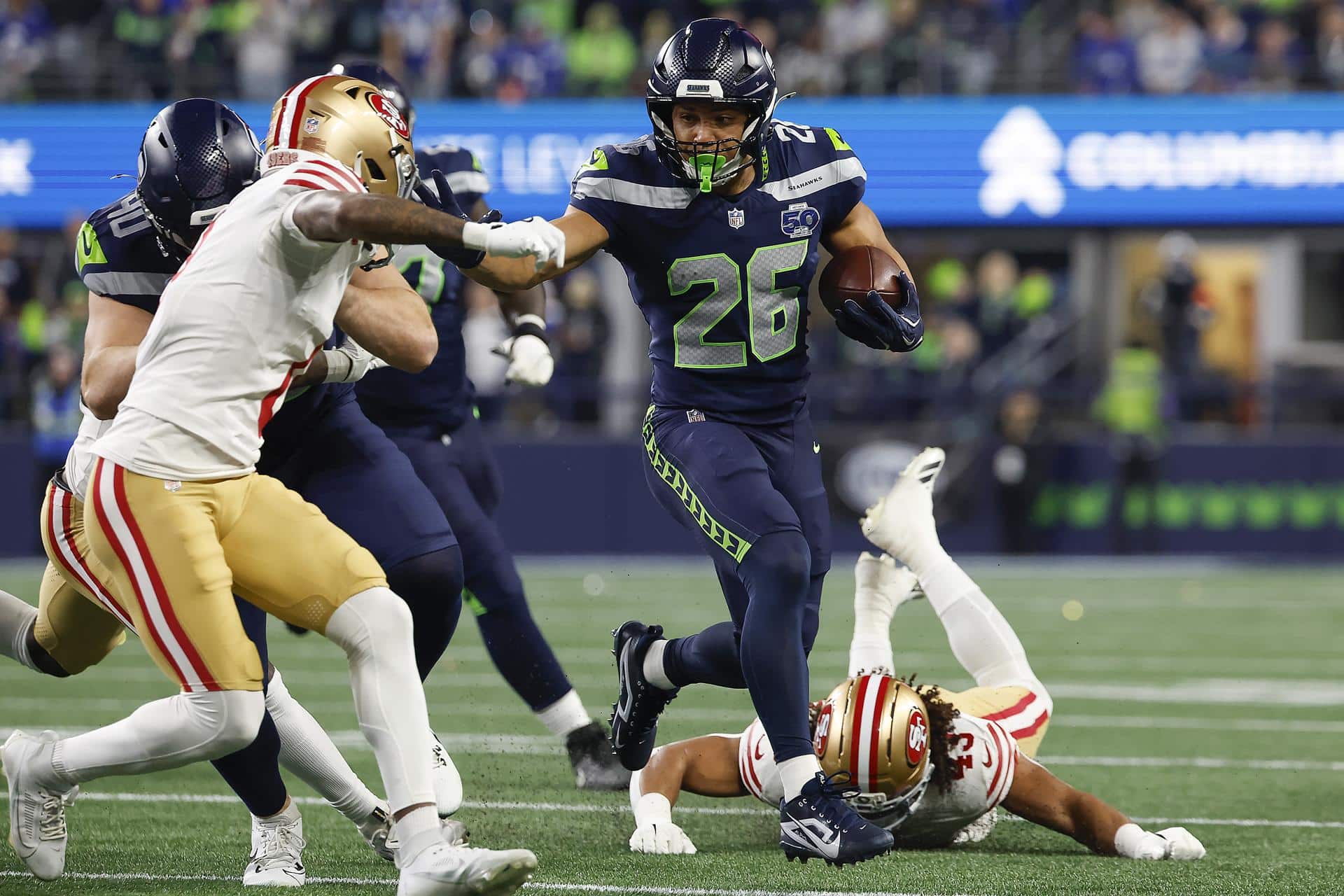 El corredor de los Seattle Seahawks, Zach Charbonnet (c), elude la marca de rivales de San Francisco 49ers durante el juego de la ronda divisiona, el 17 de enero pasado, poco antes de sufrir una delicada lesión que le hará perder el juego por el título de la Conferencia Nacional (NFC). EFE/EPA/JOHN G. MABANGLO
