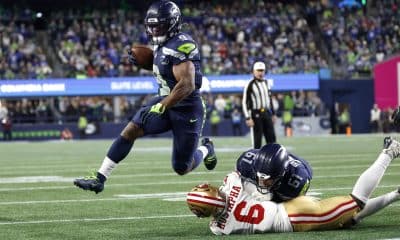 El corredor de los Seattle Seahawks, Kenneth Walker III (i), elude con un salto a Malik Mustapha de los San Francisco 49ers y anota un 'touchdown' este sábado durante el juego en Seattle (Washington). EFE/EPA/JOHN G. MABANGLO