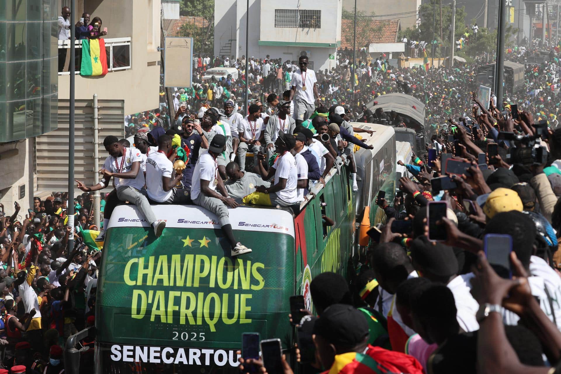 Miembros de la selección nacional de fútbol de Senegal viajan en un autobús descapotable durante el desfile de la victoria de la selección senegalesa en Dakar, Senegal. Senegal venció a Marruecos, el país anfitrión, por 1-0 en la final de la Copa Africana de Naciones de la CAF el 18 de enero de 2026. EFE/ Jerome Favre