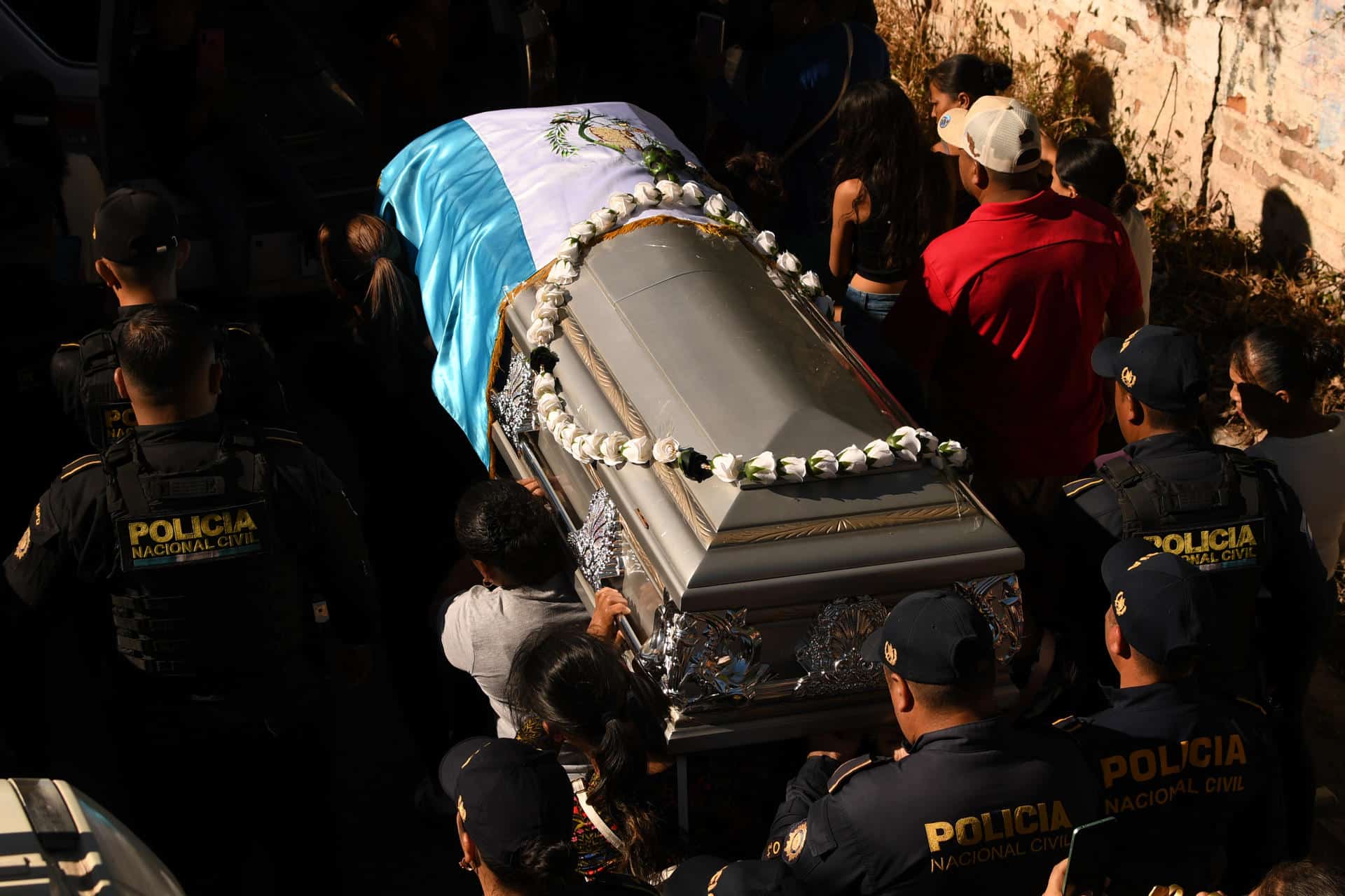 Integrantes de la Policía de Guatemala sostienen el féretro de su compañera Claudia Muñoz Ramos durante su sepelio este martes, en Jutiapa (Guatemala). EFE/ Alex Cruz