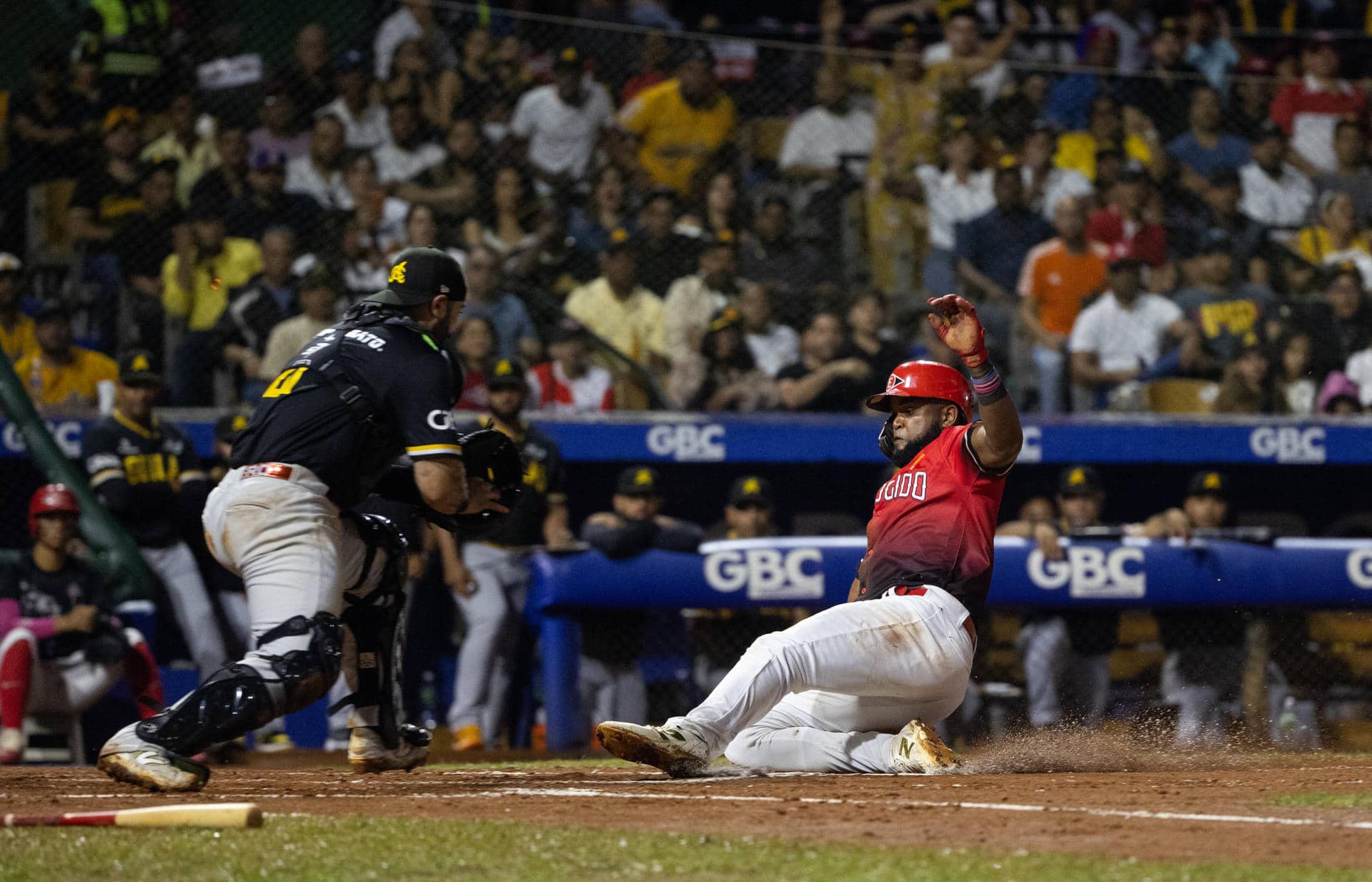 Sócrates Brito (d), de Leones del Escogido, se desliza para anotar una carrera en un partido del Torneo de Béisbol Profesional Otoño-Invierno 2025-26 entre Leones del Escogido y Águilas Cibaeñas, en el estadio Quisqueya Juan Marichal de Santo Domingo (República Dominicana). EFE/ Orlando Barría