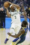 El pívot/alero de los Milwaukee Bucks Myles Turner (i) va a canasta para dos puntos mientras comete falta el alero de los Golden State Warriors Draymond Green (d) durante la primera mitad del partido de baloncesto de la NBA entre los Milwaukee Bucks y los Golden State Warriors en San Francisco, California, (EE.UU.). EFE/JOHN G. MABANGLO SHUTTERSTOCK OUT