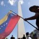 Un ciudadano venezolano ondea una bandera de su país durante una manifestación en apoyo a la intervención de Estados Unidos en Venezuela este domingo, frente al obelisco en Buenos Aires (Argentina). EFE/ Juan Ignacio Roncoroni