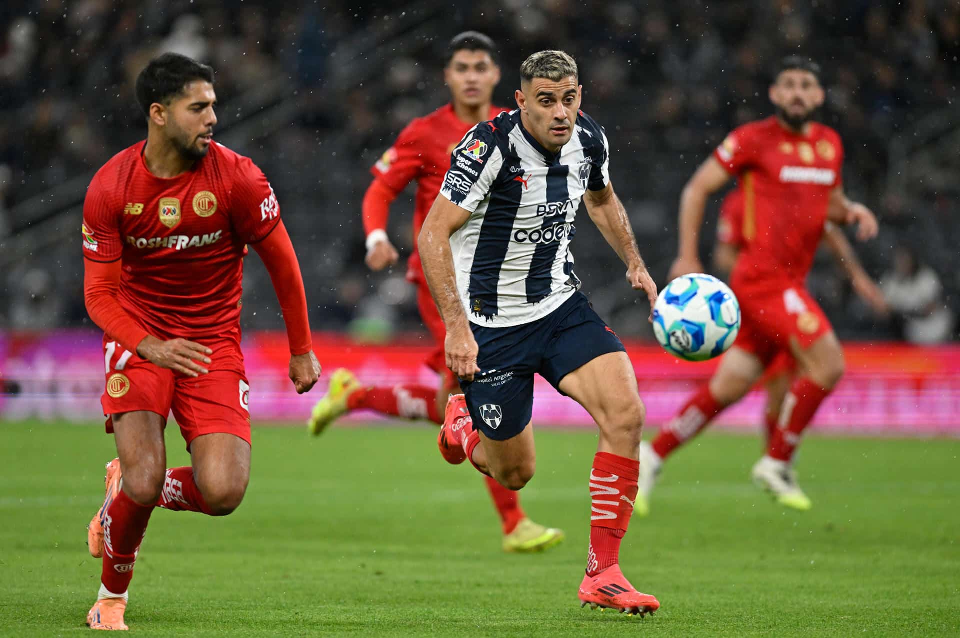 Germán Berterame (d), de Monterrey, disputa el balón con Mauricio Isais, de Toluca, en un partido por la jornada 1 del Torneo Clausura 2026 en el estadio BBVA, en Guadalupe (México). EFE/Miguel Sierra