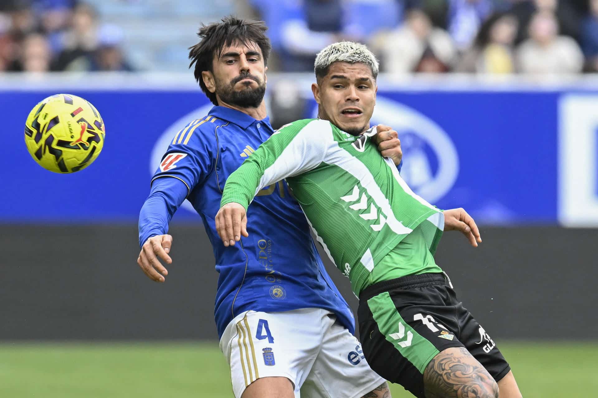 El delantero del Real Betis Cucho (d) disputa el balón con David Costas durante el partido correspondiente a la 19ª jornada de LaLiga entre el Real Oviedo y el Real Betis, este sábado, en Oviedo. EFE/ Eloy Alonso